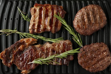 Photo of Electric grill with beef meat and rosemary, top view