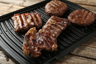 Photo of Delicious grilled beef meat on wooden table, closeup