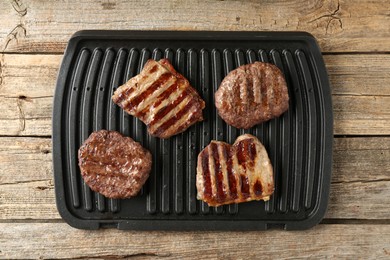 Photo of Delicious grilled beef meat on wooden table, top view