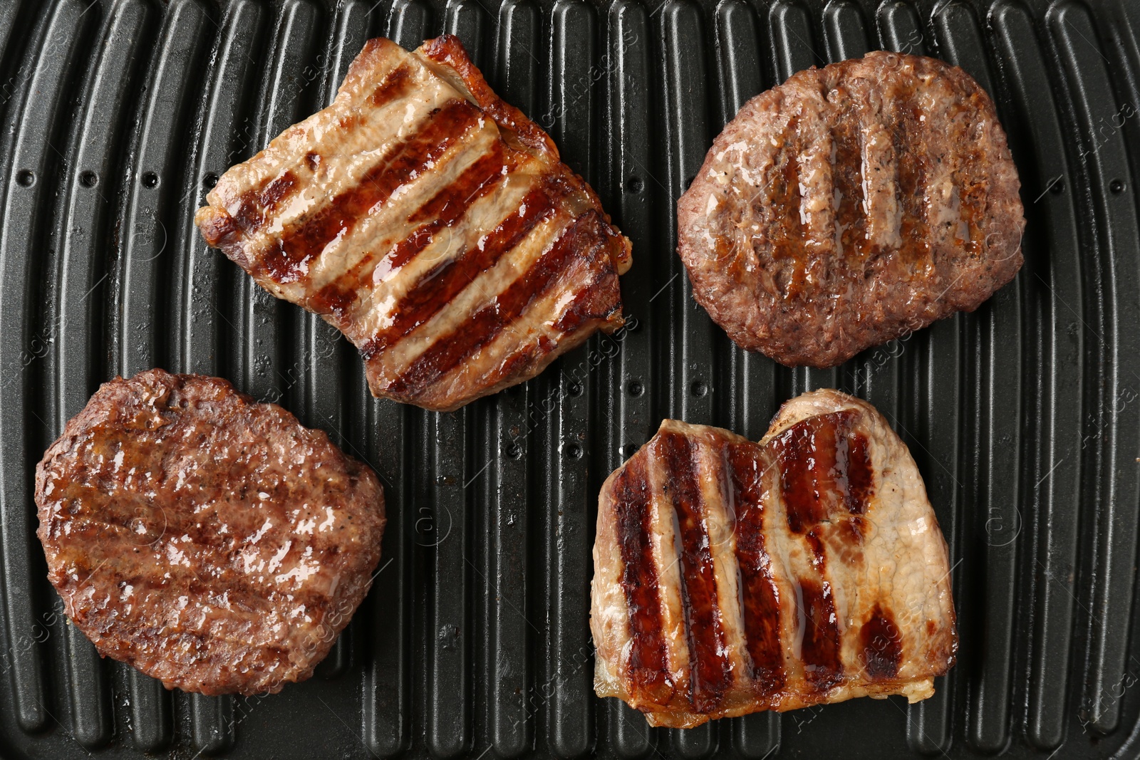 Photo of Electric grill with beef meat, top view