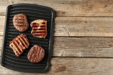 Photo of Delicious grilled beef meat on wooden table, top view. Space for text