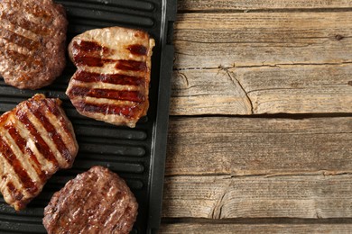 Photo of Delicious grilled beef meat on wooden table, top view. Space for text