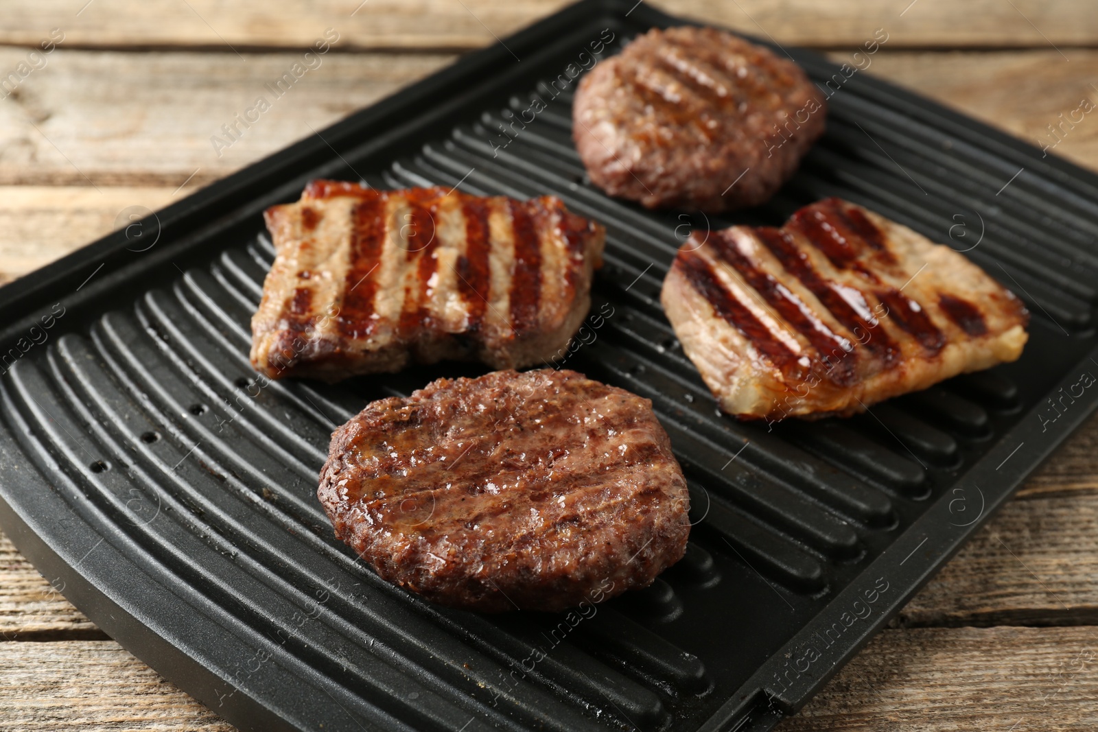Photo of Delicious grilled beef meat on wooden table, closeup