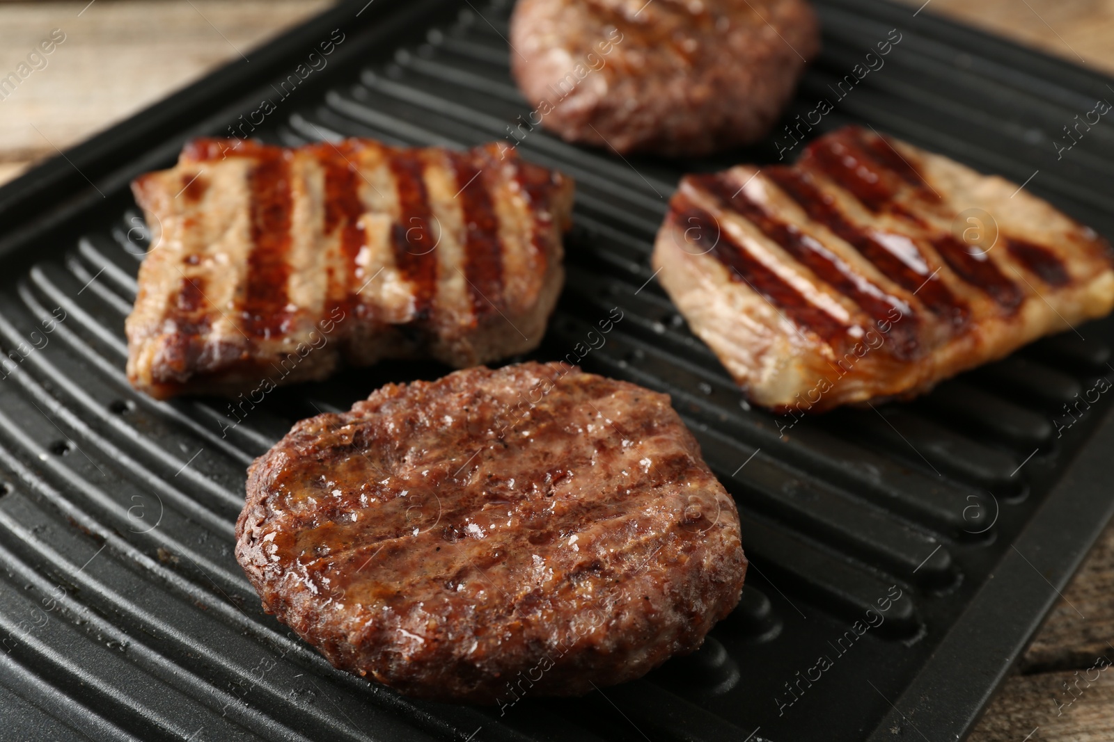 Photo of Delicious grilled beef meat on wooden table, closeup