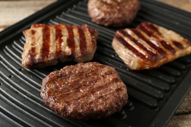 Photo of Delicious grilled beef meat on wooden table, closeup