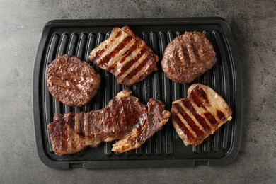 Photo of Delicious grilled beef meat on grey table, top view