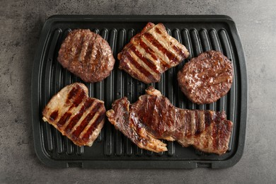 Photo of Delicious grilled beef meat on grey table, top view