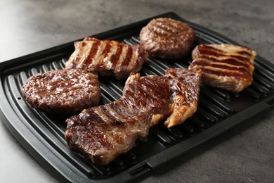 Photo of Delicious grilled beef meat on grey table, closeup