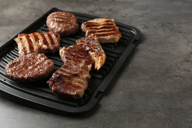 Photo of Delicious grilled beef meat on grey table, closeup. Space for text