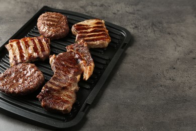 Photo of Delicious grilled beef meat on grey table, closeup. Space for text