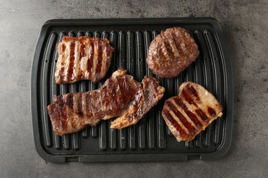 Photo of Delicious grilled beef meat on grey table, top view