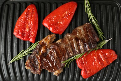 Photo of Electric grill with beef steaks, bell peppers and rosemary, closeup