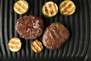 Photo of Electric grill with beef and zucchini, top view