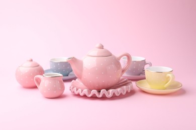 Photo of Beautiful tea set on pink background. Child's toy