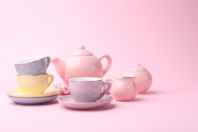Photo of Beautiful tea set on pink background, space for text. Child's toy