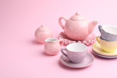 Photo of Beautiful tea set on pink background, space for text. Child's toy