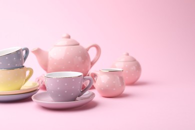 Photo of Beautiful tea set on pink background, space for text. Child's toy