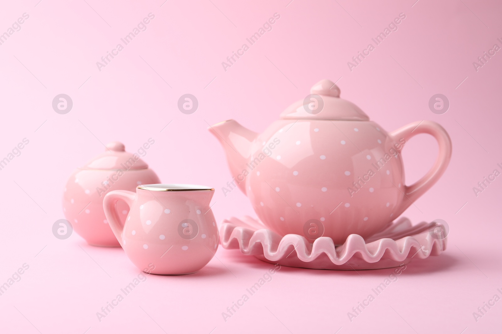 Photo of Beautiful tea set on pink background. Child's toy