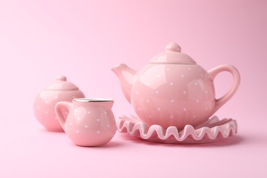 Photo of Beautiful tea set on pink background. Child's toy
