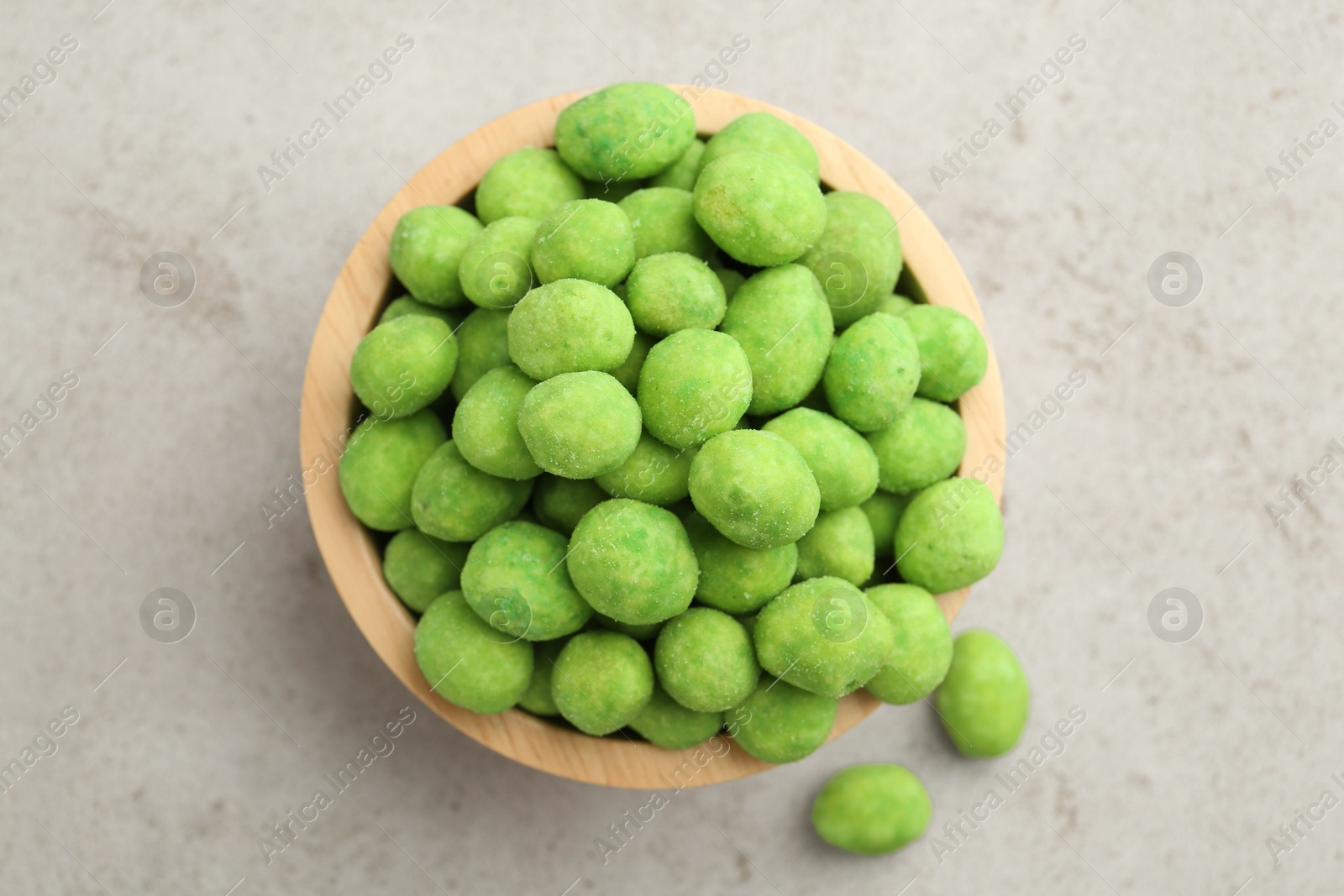Photo of Wasabi coated peanuts in bowl on light table, top view
