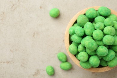 Photo of Wasabi coated peanuts in bowl on light table, top view. Space for text