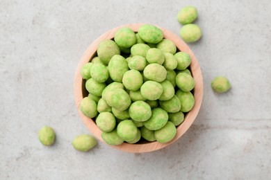 Photo of Wasabi coated peanuts in bowl on light table, top view