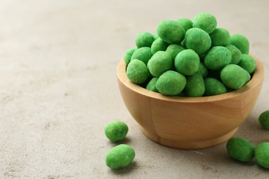 Photo of Wasabi coated peanuts in bowl on light table, closeup. Space for text