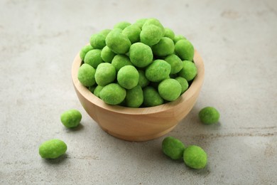 Photo of Wasabi coated peanuts in bowl on light table, closeup