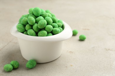 Photo of Wasabi coated peanuts in bowl on light table, closeup. Space for text