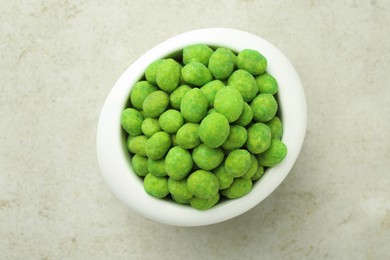 Photo of Wasabi coated peanuts in bowl on light table, top view