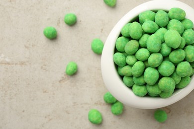 Photo of Wasabi coated peanuts in bowl on light table, top view