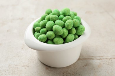 Photo of Wasabi coated peanuts in bowl on light table, closeup