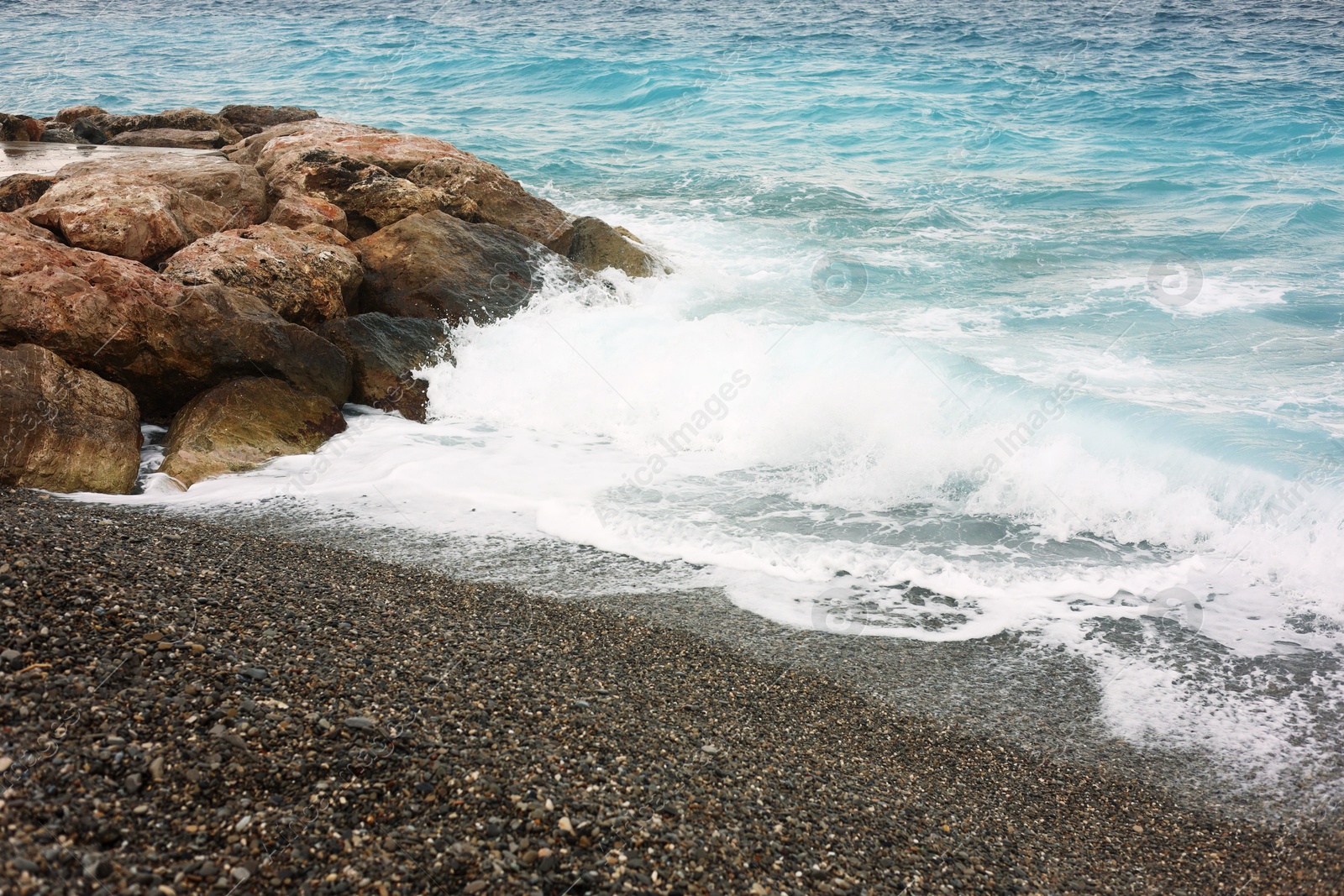 Photo of Beautiful view of wavy sea and pebbles on beach