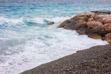 Photo of Beautiful view of wavy sea and pebbles on beach