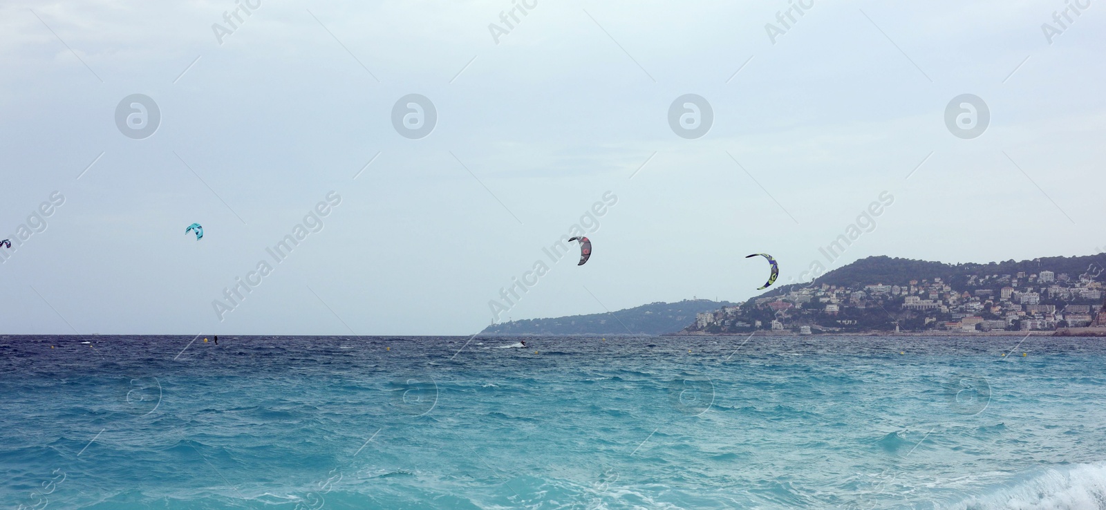 Photo of Beautiful view of wavy sea, city and pebbles on beach