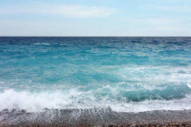 Photo of Beautiful view of wavy sea and pebbles on beach