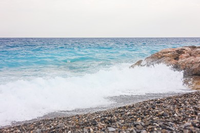 Photo of Beautiful view of wavy sea and pebbles on beach