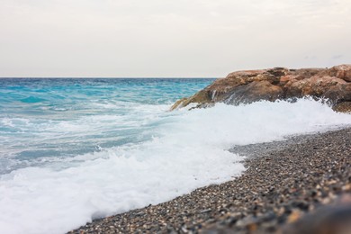 Photo of Beautiful view of wavy sea and pebbles on beach