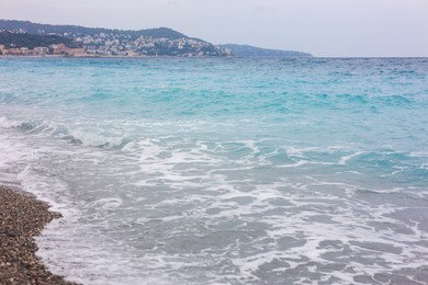Photo of Beautiful view of wavy sea and pebbles on beach