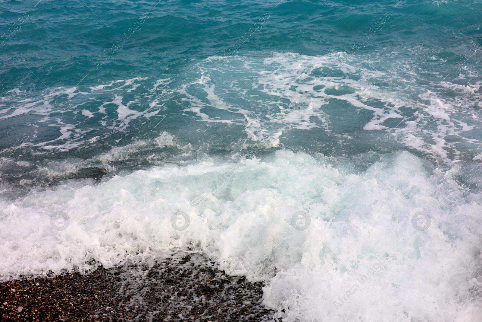 Photo of Beautiful view of wavy sea and pebbles on beach