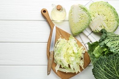 Photo of Fresh cut Savoy cabbage and knife on white table, flat lay. Space for text