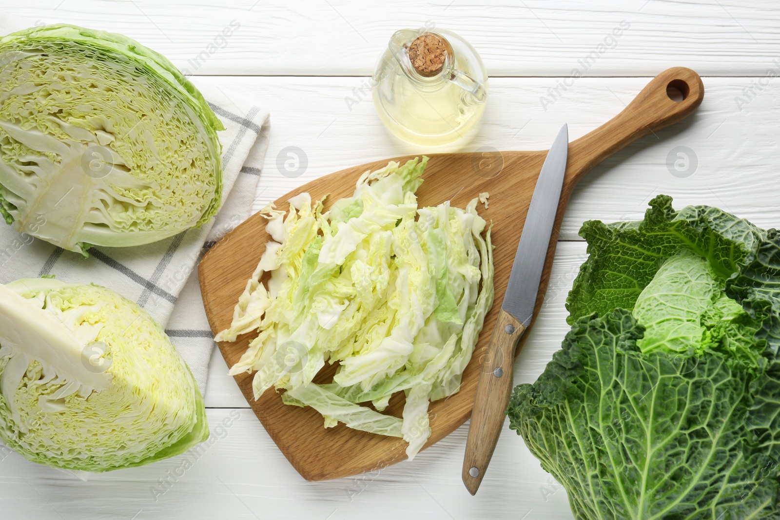 Photo of Fresh cut Savoy cabbage and knife on white table, flat lay