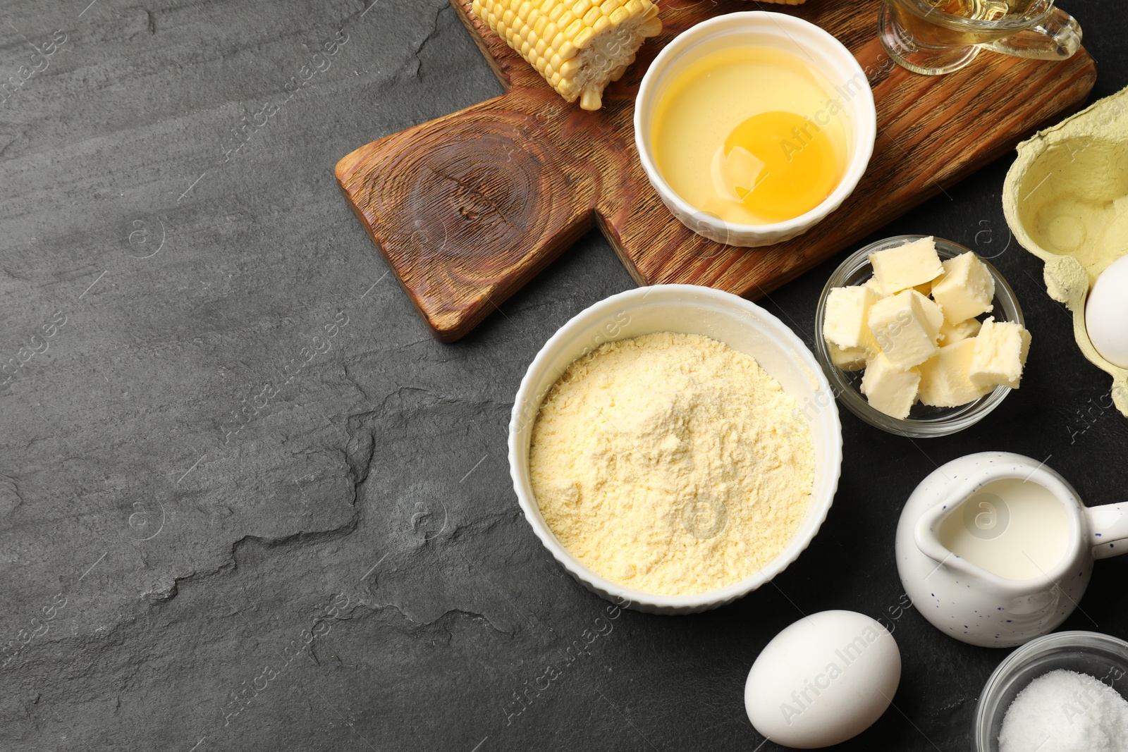 Cornbread preparation. Different ingredients on black textured table, flat lay. Space for text Photo of Cornbread preparation. Different ingredients on black textured table, flat lay. Space for text