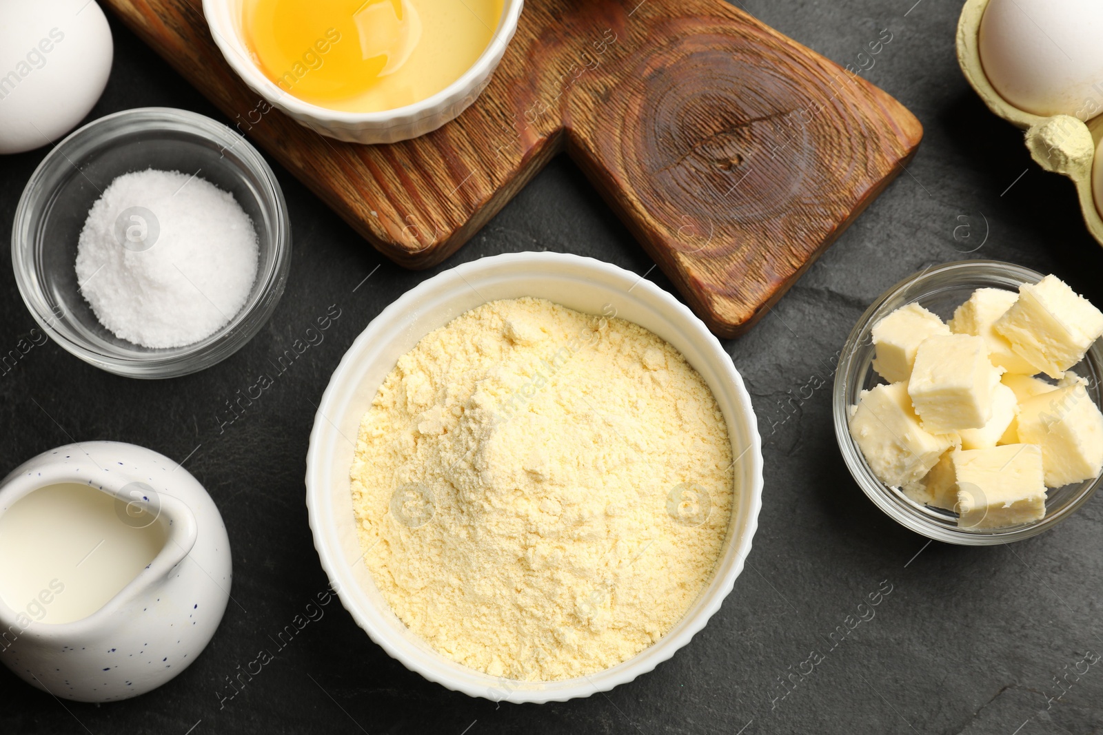 Photo of Cornbread preparation. Different ingredients on black textured table, flat lay
