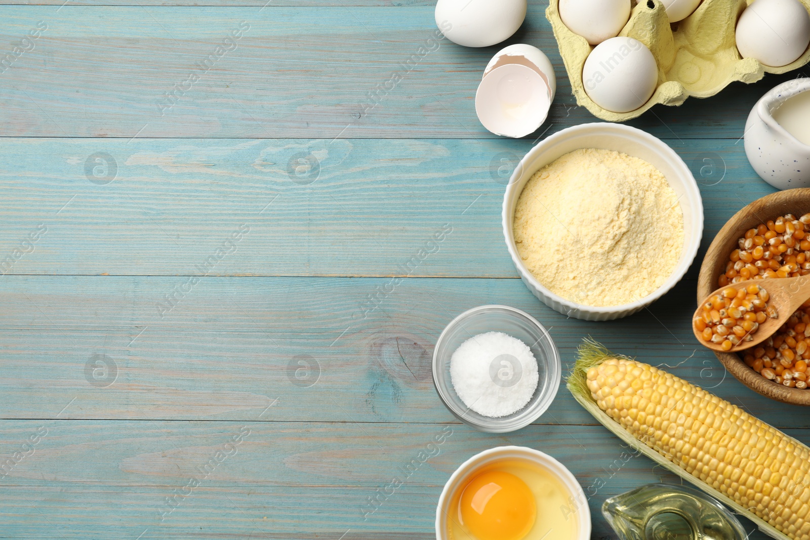Photo of Cornbread preparation. Different ingredients on light blue wooden table, flat lay. Space for text