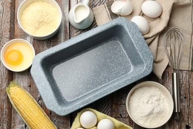 Photo of Making cornbread. Baking dish, different ingredients and whisk on wooden table, flat lay