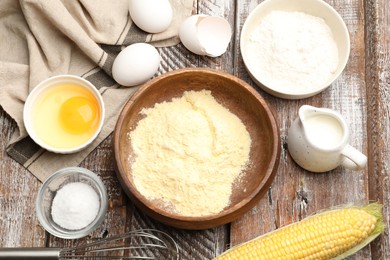 Photo of Making cornbread. Different ingredients and metal whisk on wooden table, flat lay
