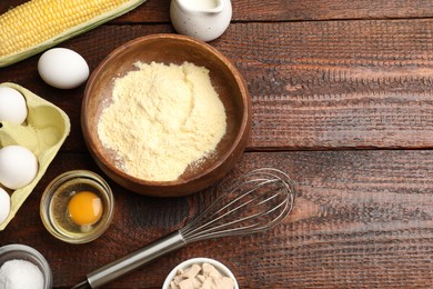 Photo of Making cornbread. Different ingredients and metal whisk on wooden table, flat lay. Space for text