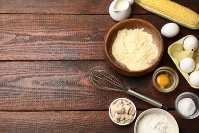 Photo of Making cornbread. Different ingredients and metal whisk on wooden table, flat lay. Space for text