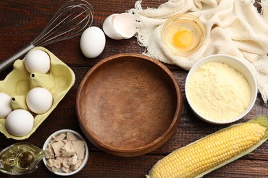 Photo of Making cornbread. Different ingredients and metal whisk on wooden table, flat lay